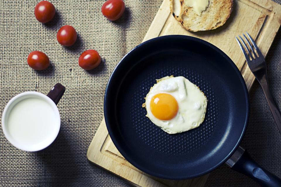 A fried egg in a pan with tomatoes